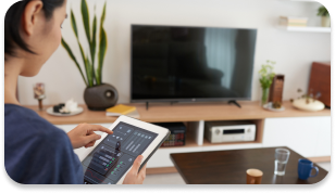 A person working on a digital tablet in the comfort of her home.