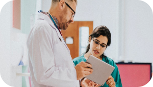 A doctor discussing the patient's report with a nurse using a digital tablet.