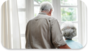 An elderly couple looking out of the window and admiring the view.